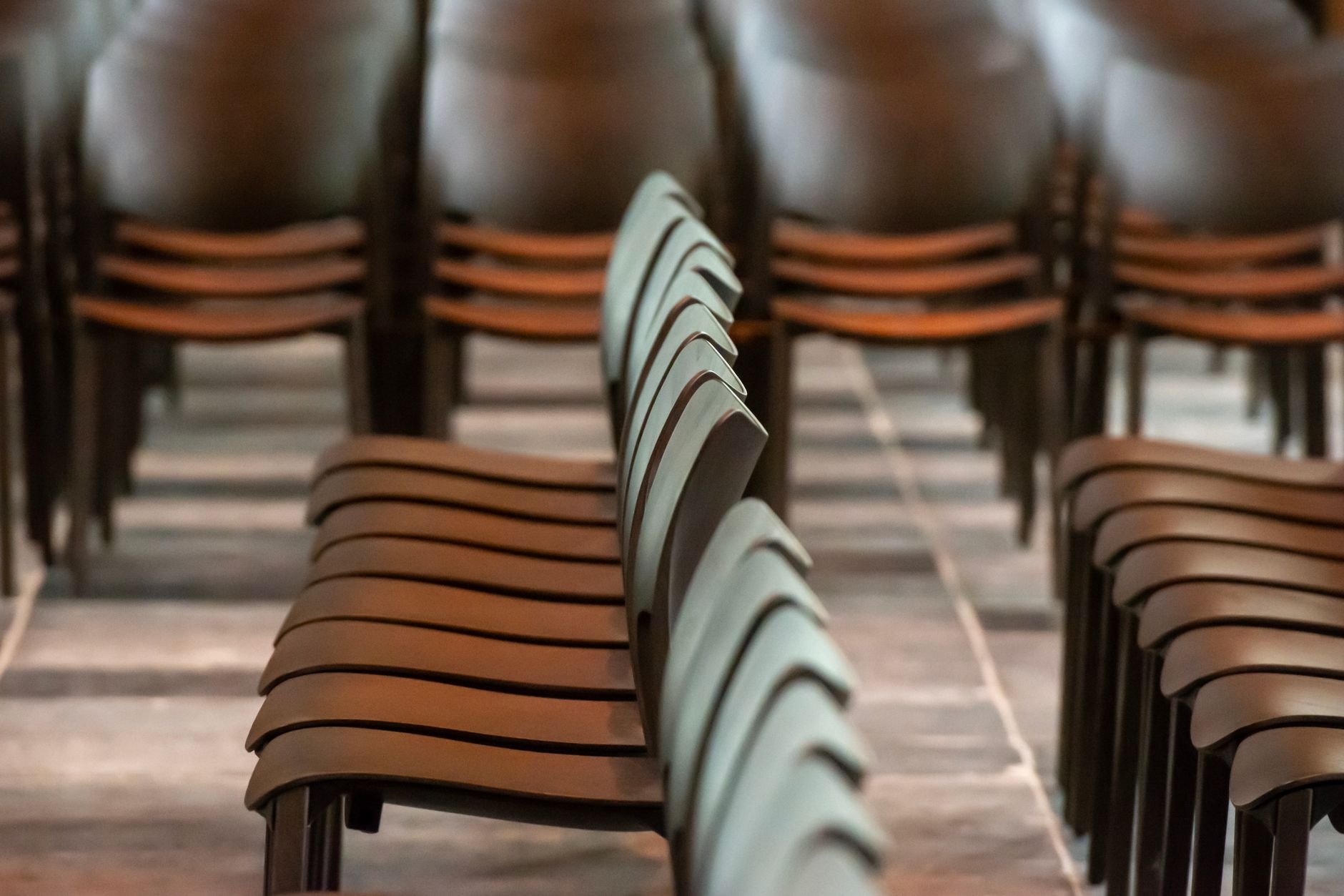 rows of stacked chairs in indoor setting